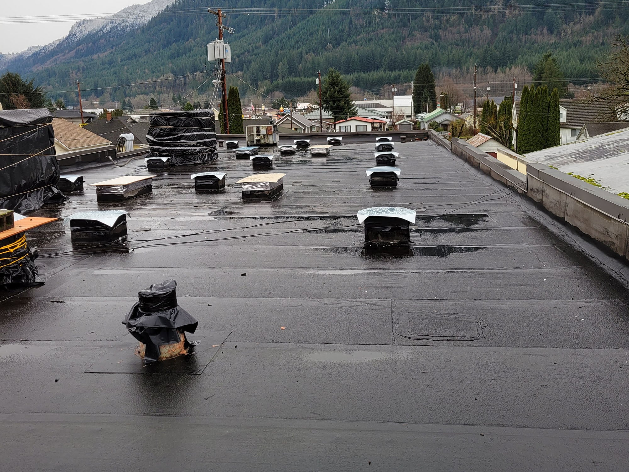 Rooftop ductwork removed except for openings with temporary covers.